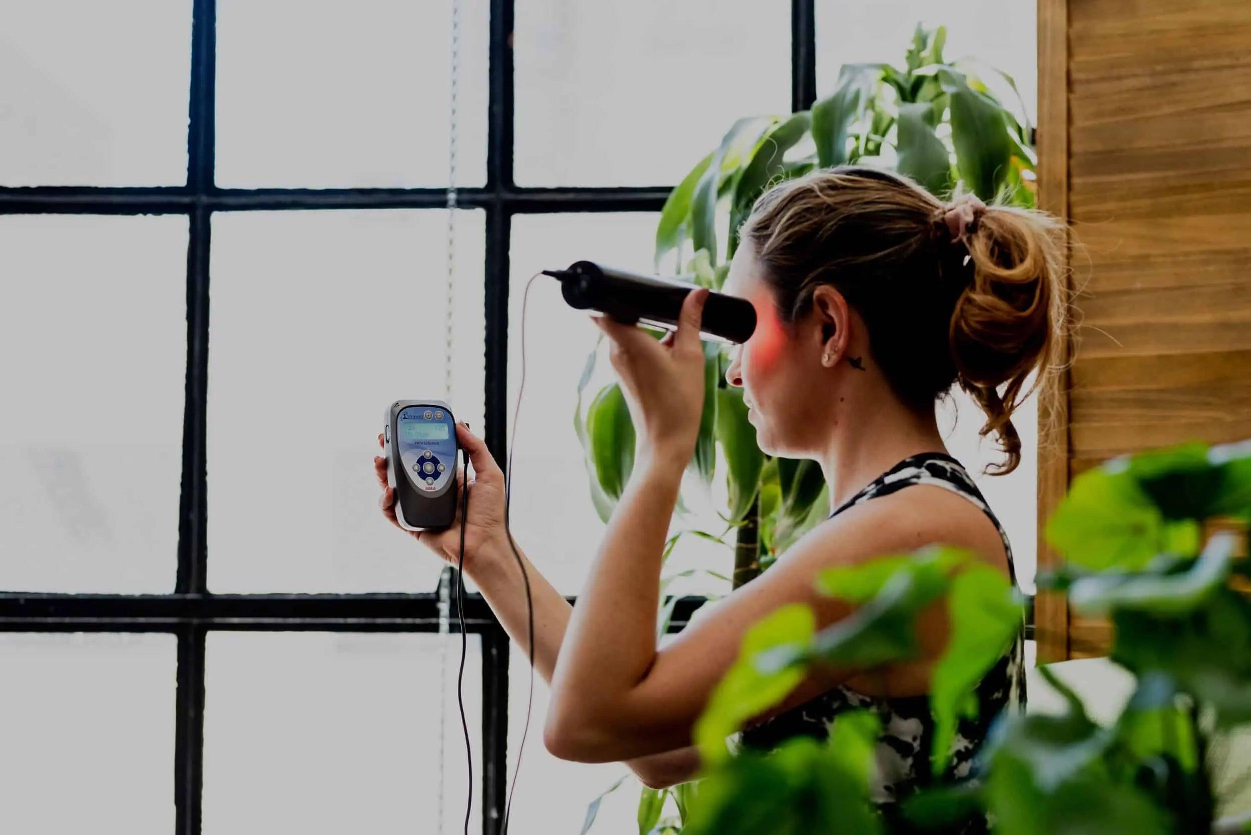photo of a woman using the biotransducer pro on the side of her temple