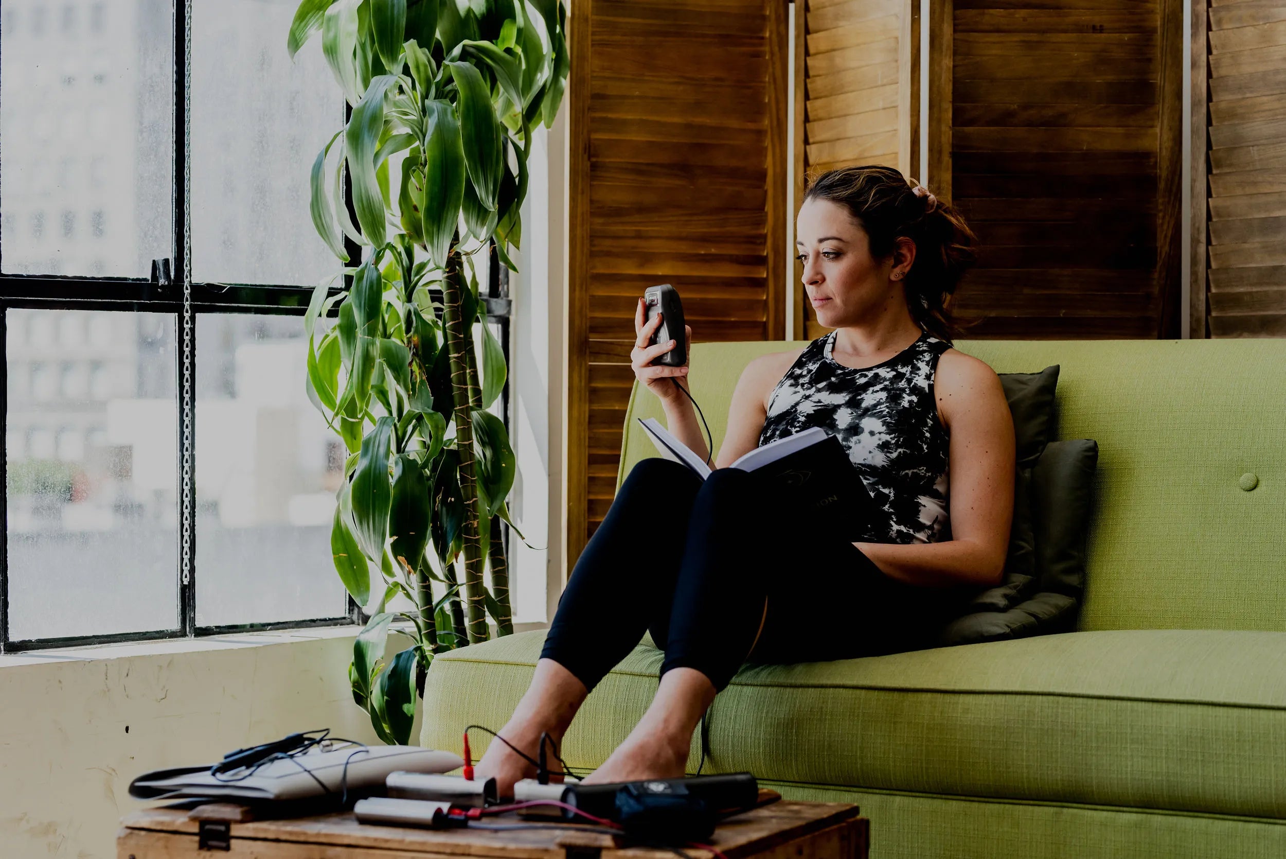 woman reading on the couch while using the footplates