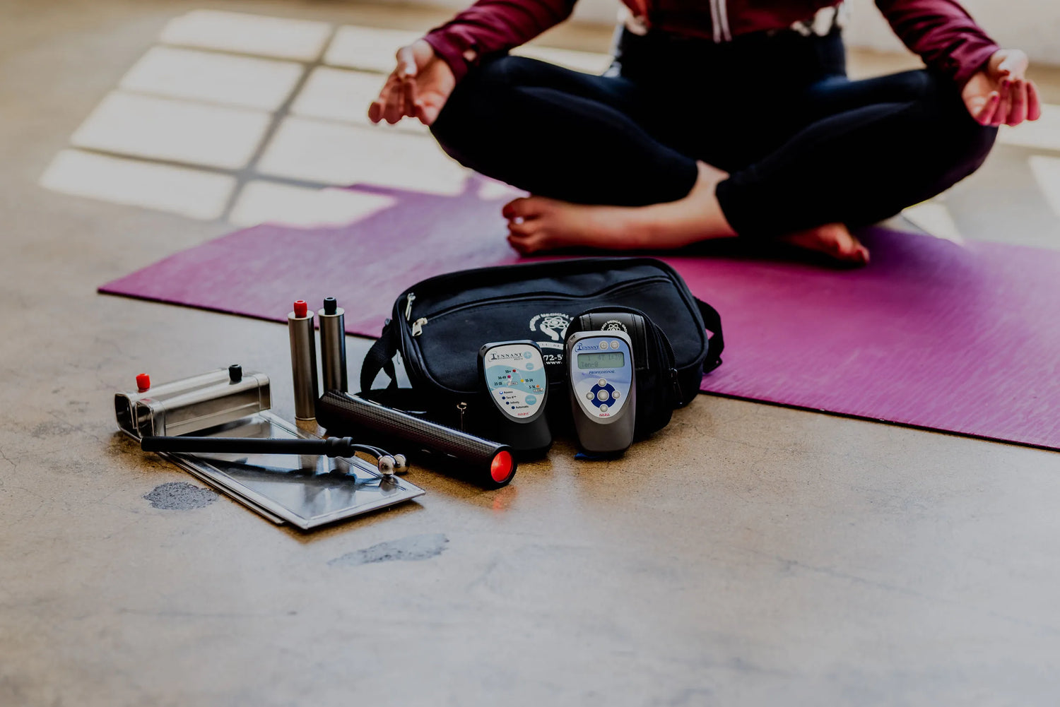 photo of a workout mat that has hand weights, both the biomodulator pro and plus, large and small carrying case and biotransducer pro
