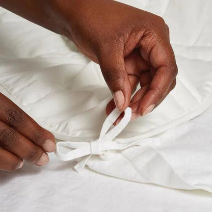 person tying the white duvet